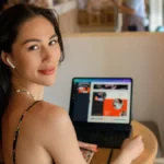 Woman working on laptop while creating Black Friday Ads in a cafe