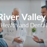 River Valley Health and Dental: Healthcare providers discussing with a patient in a medical and dental office.