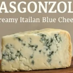 A wedge of creamy Masgonzola Italian blue cheese with rich blue veining, presented on a rustic wooden cheeseboard.
