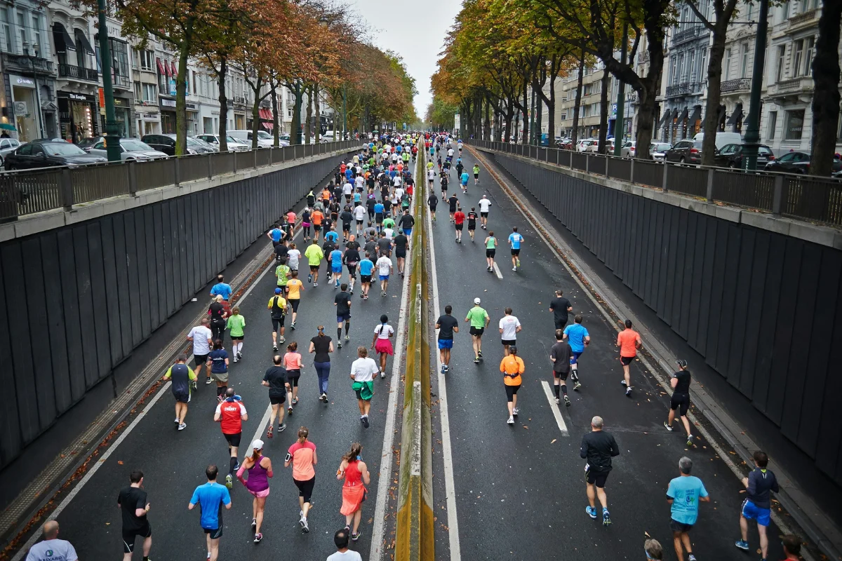 Medias Maratones España runners competing in a large city half marathon on a tree-lined urban road